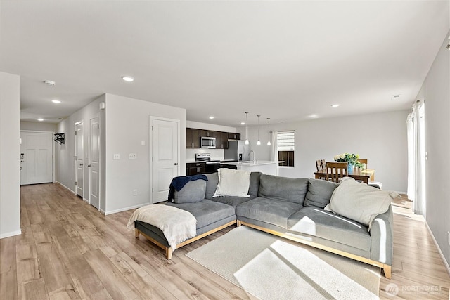 9206 Conine St SE, Yelm, WA 98597 - living area with light wood-type flooring, recessed lighting, and baseboards