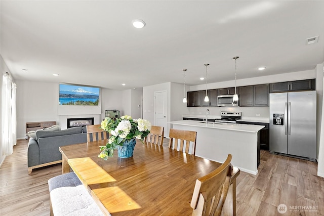 9206 Conine St SE, Yelm, WA 98597 - dining space with recessed lighting, light wood-style flooring, a fireplace, and baseboards