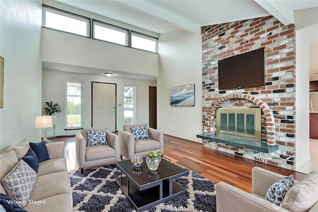 3122 N Vassault St, Tacoma, WA 98407 - living area featuring wood finished floors, beam ceiling, a brick fireplace, and a high ceiling