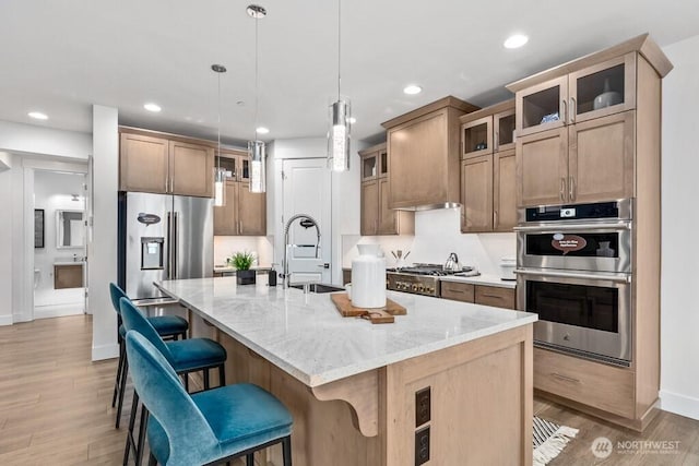 19507 81st Pl NE Unit 3, Kenmore, WA 98028 - kitchen featuring stainless steel appliances, a sink, recessed lighting, light stone counters, and light wood-style flooring