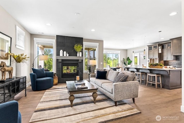 19507 81st Pl NE Unit 3, Kenmore, WA 98028 - living room featuring light wood finished floors, a multi sided fireplace, and recessed lighting