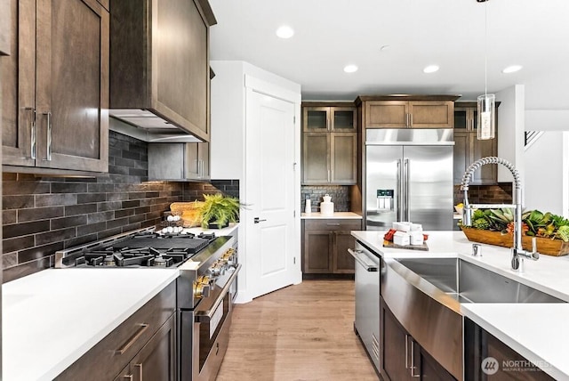 19507 81st Pl NE Unit 3, Kenmore, WA 98028 - kitchen with premium appliances, light countertops, decorative backsplash, decorative light fixtures, and light wood-style floors