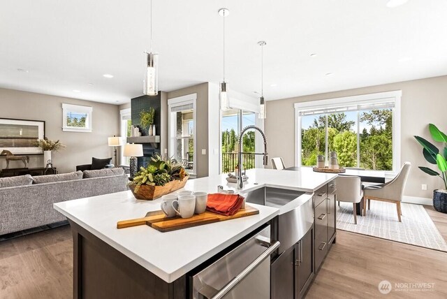 19507 81st Pl NE Unit 3, Kenmore, WA 98028 - kitchen featuring stainless steel dishwasher, light countertops, light wood-type flooring, open floor plan, and an island with sink