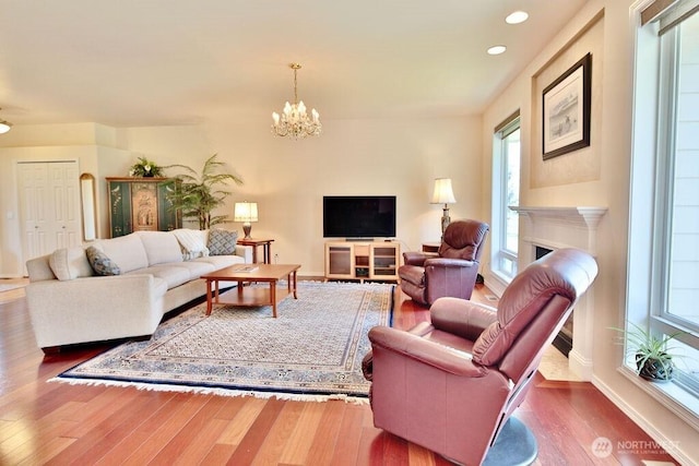 living area with an inviting chandelier, wood finished floors, plenty of natural light, and recessed lighting