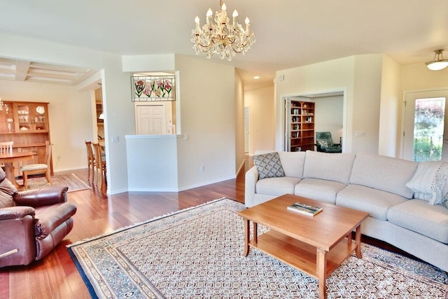 living room featuring baseboards, an inviting chandelier, and wood finished floors
