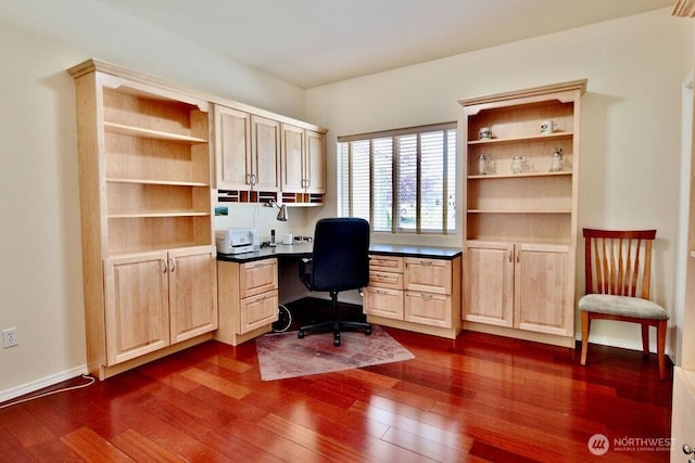 home office featuring built in study area and dark wood-style flooring