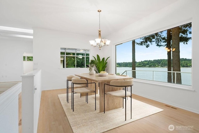 3236 Gravelly Beach Loop NW, Olympia, WA 98502 - dining space featuring a chandelier, light wood finished floors, a water view, and baseboards