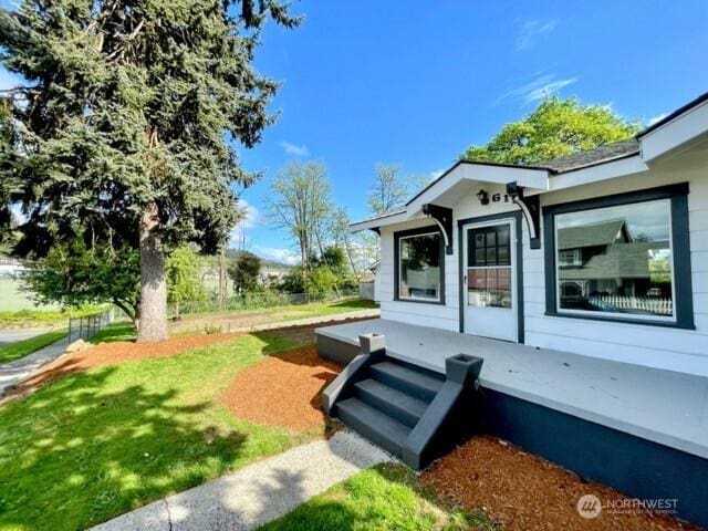 property entrance with a lawn