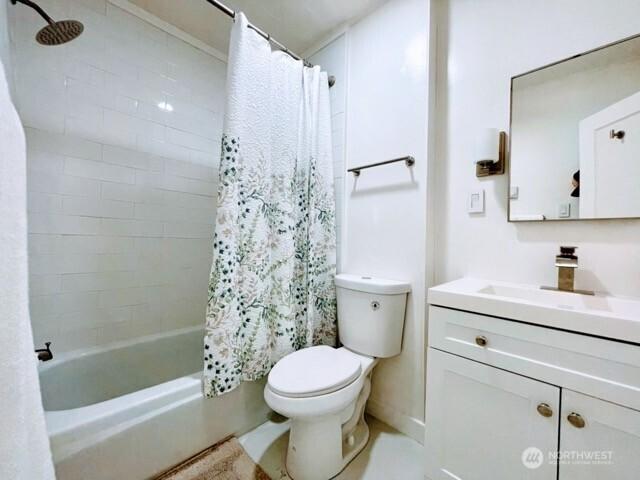 bathroom featuring toilet, vanity, and shower / bath combination with curtain