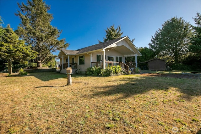 348 Cockle St SW, Ocean Shores, WA 98569 - rear view of house featuring covered porch, an outdoor structure, a lawn, and a storage unit