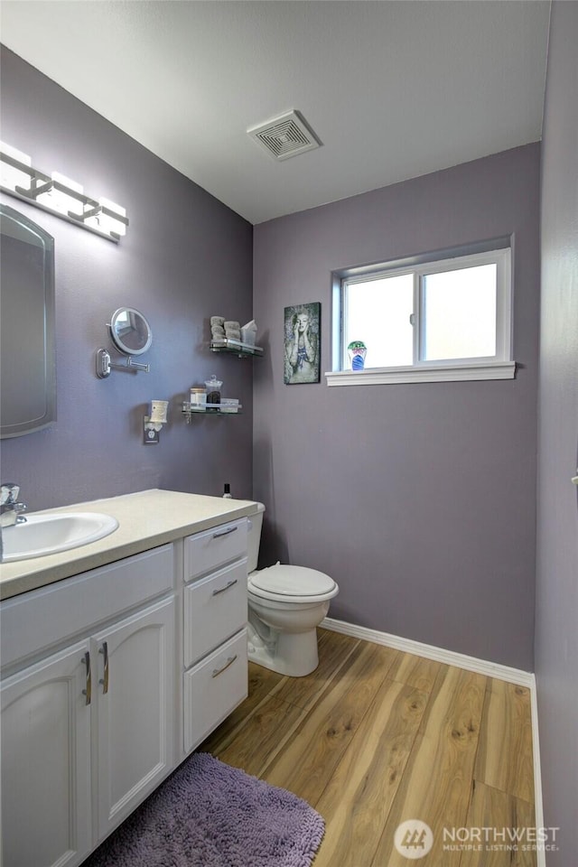 348 Cockle St SW, Ocean Shores, WA 98569 - half bathroom with toilet, wood finished floors, visible vents, baseboards, and vanity