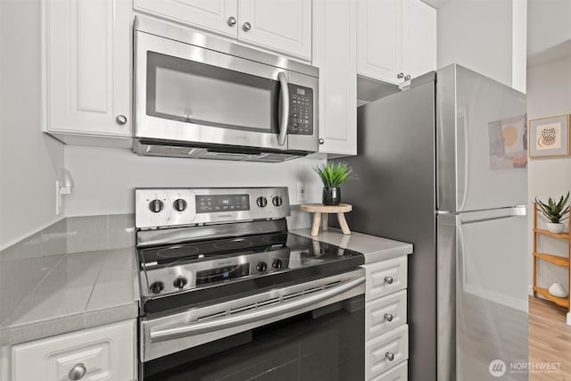 321 10th Ave S Unit 705, Seattle, WA 98104 - kitchen with stainless steel appliances, white cabinets, and light countertops
