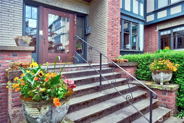 entrance to property featuring brick siding