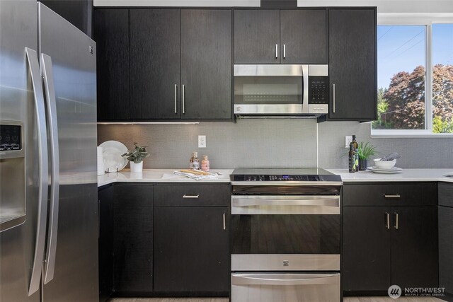 kitchen with appliances with stainless steel finishes, light countertops, and plenty of natural light