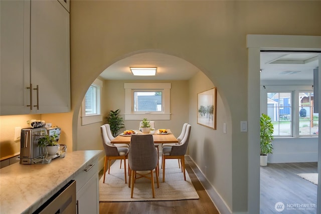 1813 10th St, Anacortes, WA 98221 - dining area featuring wood finished floors, arched walkways, baseboards, and wine cooler