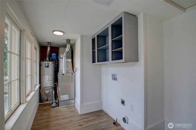 1813 10th St, Anacortes, WA 98221 - washroom with water heater, hookup for a washing machine, electric dryer hookup, wood finished floors, and healthy amount of natural light