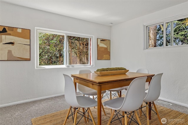 carpeted dining area with baseboards