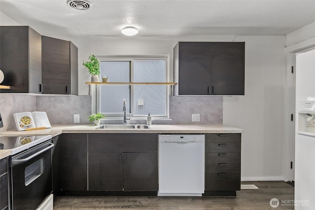 kitchen featuring electric range oven, dishwasher, a sink, dark wood-style floors, and light countertops