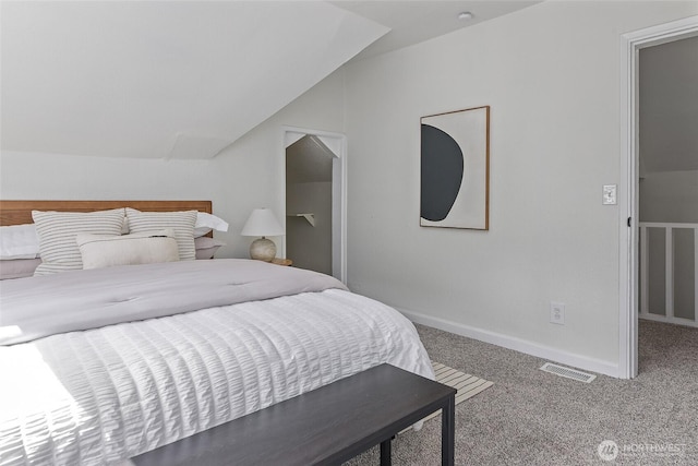 carpeted bedroom featuring vaulted ceiling and baseboards
