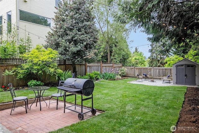 view of yard featuring a fire pit, a shed, a patio, and an outbuilding