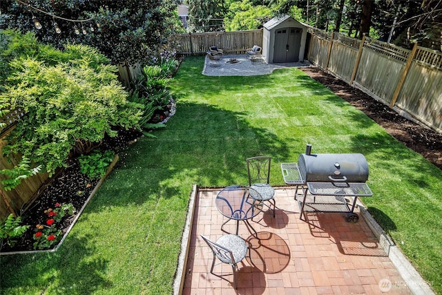 view of yard featuring a shed, a patio area, and an outbuilding