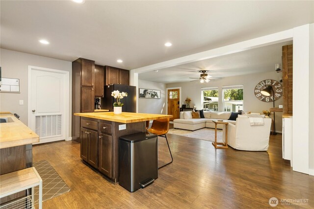 kitchen with wood counters, freestanding refrigerator, dark brown cabinets, dark wood-style flooring, and recessed lighting