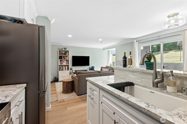 12515 109th Ct NE Unit B104, Kirkland, WA 98034 - kitchen with freestanding refrigerator, a sink, light wood-type flooring, white cabinetry, and plenty of natural light