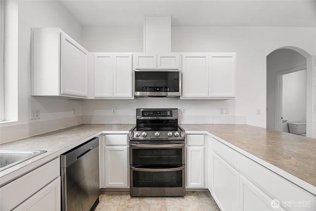 3516 Preston St NE, Lacey, WA 98516 - kitchen with stainless steel appliances, white cabinetry, arched walkways, and light countertops