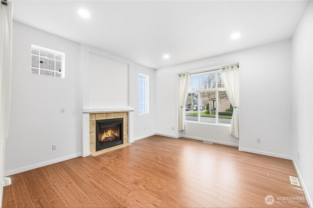 3516 Preston St NE, Lacey, WA 98516 - unfurnished living room featuring a tiled fireplace, baseboards, recessed lighting, and light wood-style floors