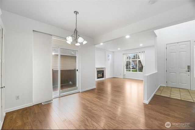 3516 Preston St NE, Lacey, WA 98516 - unfurnished living room featuring wood finished floors, a glass covered fireplace, recessed lighting, a chandelier, and baseboards