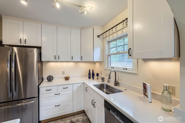 2523 Royal Ct E, Seattle, WA 98112 - kitchen featuring freestanding refrigerator, a sink, white cabinets, and light countertops