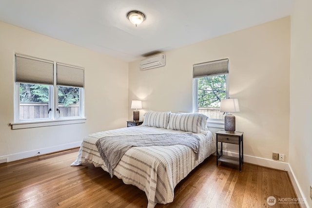 2523 Royal Ct E, Seattle, WA 98112 - bedroom with a wall unit AC, hardwood / wood-style floors, and baseboards