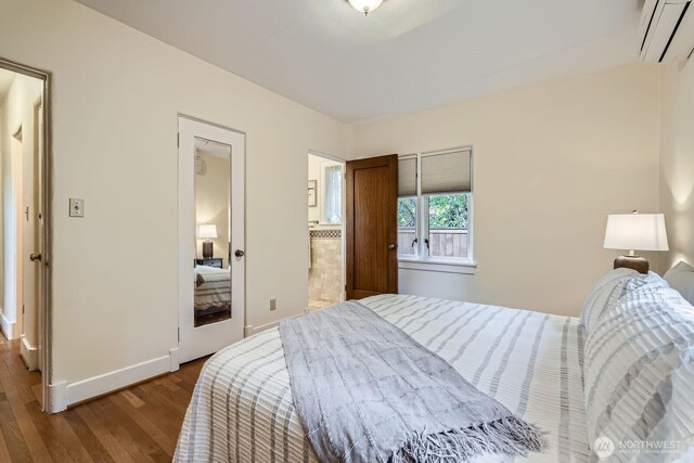 2523 Royal Ct E, Seattle, WA 98112 - bedroom featuring a wall mounted air conditioner, wood finished floors, and baseboards