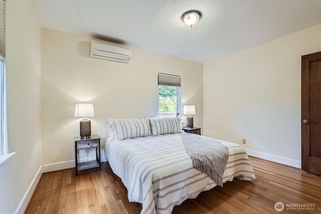 2523 Royal Ct E, Seattle, WA 98112 - bedroom with an AC wall unit, wood finished floors, and baseboards