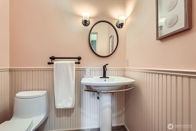2523 Royal Ct E, Seattle, WA 98112 - half bathroom featuring a wainscoted wall and toilet