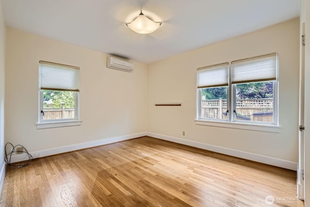 2523 Royal Ct E, Seattle, WA 98112 - unfurnished room with a wall mounted AC, light wood-style flooring, and baseboards