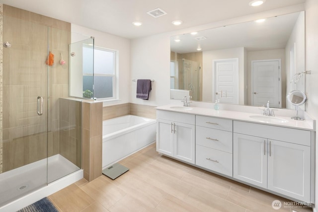 bathroom featuring a sink, a garden tub, a stall shower, and visible vents