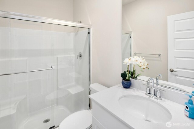 full bath with vanity, toilet, and a shower stall