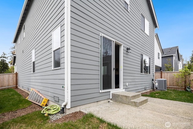 view of side of property featuring central AC, a patio area, and a fenced backyard