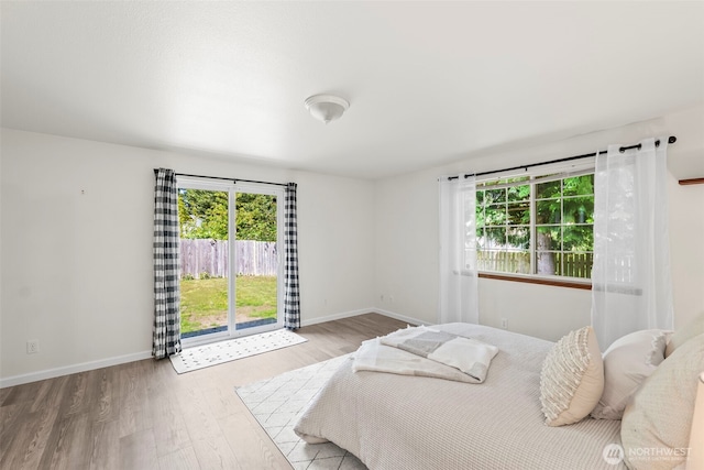 bedroom featuring multiple windows, wood finished floors, and baseboards