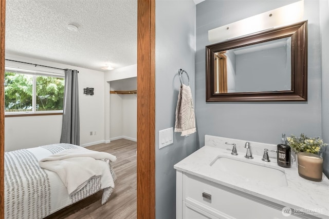 bathroom with a textured ceiling, wood finished floors, and vanity