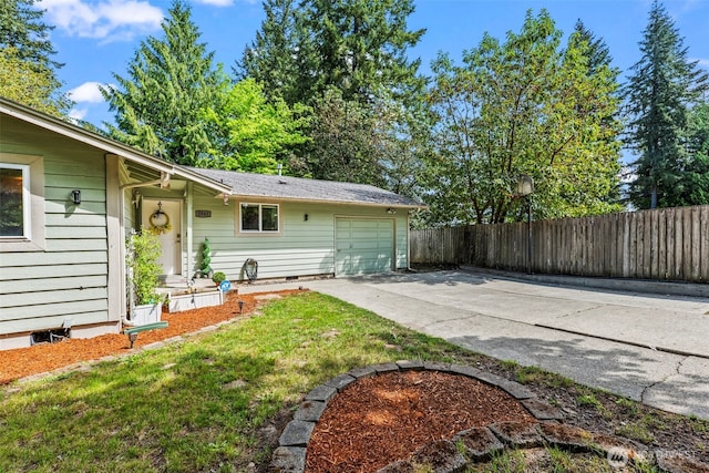 exterior space featuring concrete driveway, an attached garage, and fence