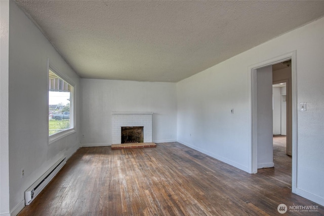 1306 Morgan St, Aberdeen, WA 98520 - unfurnished living room with a baseboard radiator, hardwood / wood-style floors, a textured ceiling, a brick fireplace, and baseboards