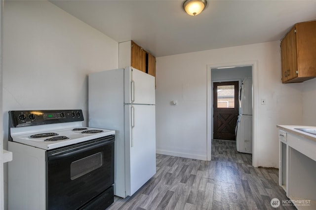 1306 Morgan St, Aberdeen, WA 98520 - kitchen featuring electric range, brown cabinets, light wood finished floors, freestanding refrigerator, and light countertops
