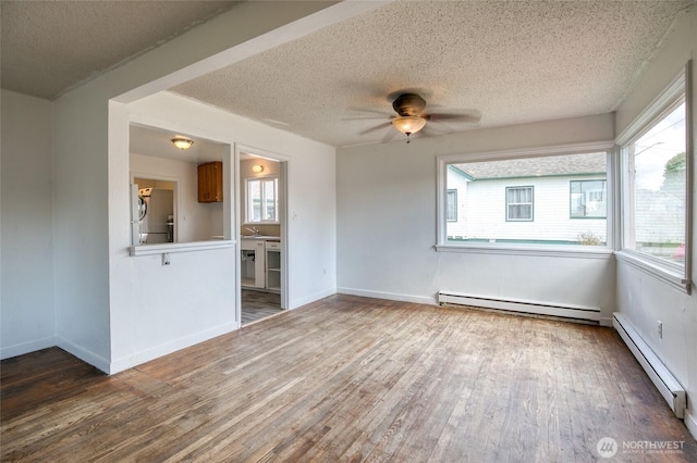 1306 Morgan St, Aberdeen, WA 98520 - unfurnished room with a baseboard radiator, wood finished floors, healthy amount of natural light, and a textured ceiling