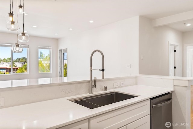 kitchen with a sink, white cabinetry, light countertops, recessed lighting, and stainless steel dishwasher