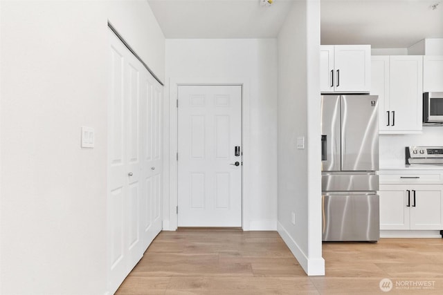 kitchen featuring appliances with stainless steel finishes, white cabinetry, and light wood finished floors