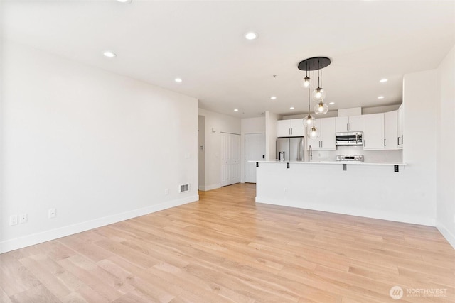 unfurnished living room featuring light wood-style flooring, baseboards, and recessed lighting