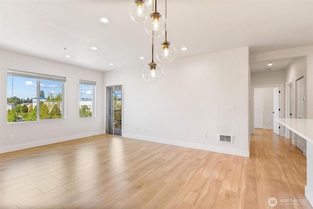 empty room featuring recessed lighting, light wood finished floors, and baseboards