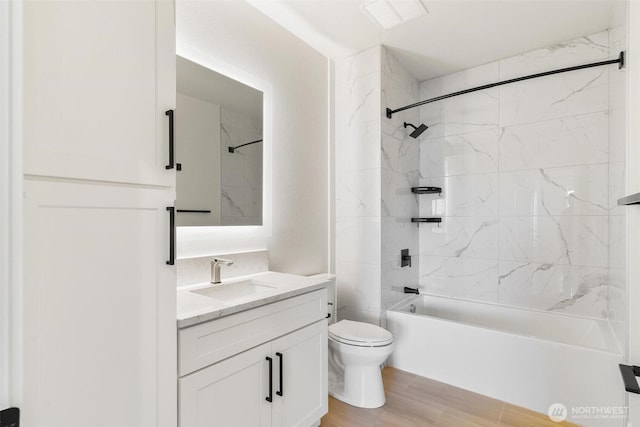 full bathroom featuring vanity, toilet,  shower combination, and wood finished floors